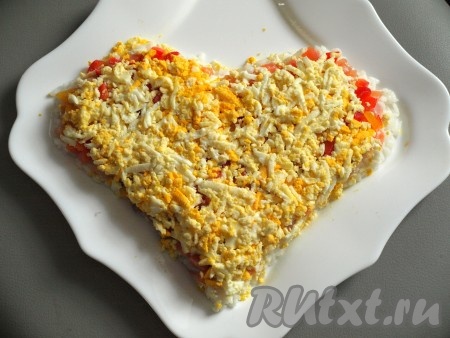 Следующим слоем выкладываем яйца, натертые на тёрке.
