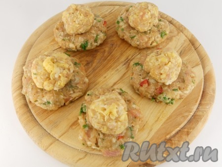 Меньшую часть фарша смешать с натертым на терке сыром, скатать шарики, величиной с грецкий орех. Из большей части фарша сформировать лепешки, в середину каждой поместить шарики с сыром.