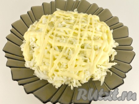 Белки отделяем от желтков. Натираем белки на крупной тёрке, желтки - на мелкой. Белки выкладываем на горошек, смазываем майонезом.