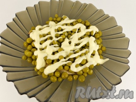 Засыпаем шпроты горошком, смазываем майонезом.