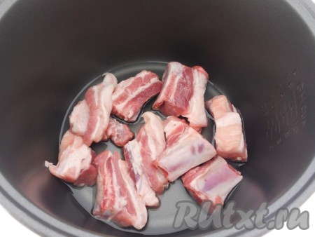 Свиные ребра помыть, обсушить и порезать на части. Поместить в чашу мультиварки, влить растительное масло. Выставить режим "Обжаривание" на 10 минут.
