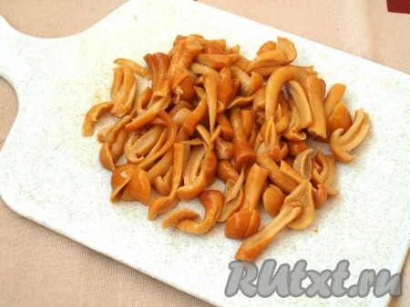 Мелкие маринованные опята будем добавлять в салат целиком, а крупные разрежем на несколько частей.
