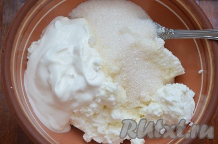 Творог перемешать со сметаной или сливками и сахаром в однородную массу.