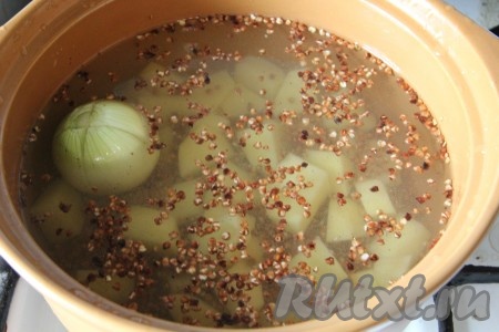 В кастрюле вскипятить 2 литра воды, выложить очищенную луковицу целиком, добавить обжаренную гречку, очищенный и нарезанный на средние ломтики картофель, дать закипеть, а затем варить на небольшом огне 15-20 минут (до готовности картошки и гречки).