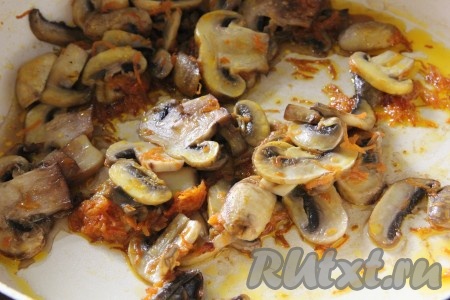 Пока крупа и картошка варятся, займёмся шампиньонами. Грибы промыть водой, убирая с них грязь, нарезать на пластины. Морковку очистить и натереть на крупной тёрке. На сковороде разогреть растительное масло, выложить натёртую морковку и обжаривать её 4-5 минут (до золотистого цвета), иногда помешивая, на среднем огне, затем добавить шампиньоны и обжаривать минут 10 (до готовности грибов), помешивая время от времени.