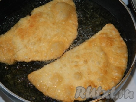 Затем аккуратно перевернуть чебуреки и жарить до румяности с другой стороны.