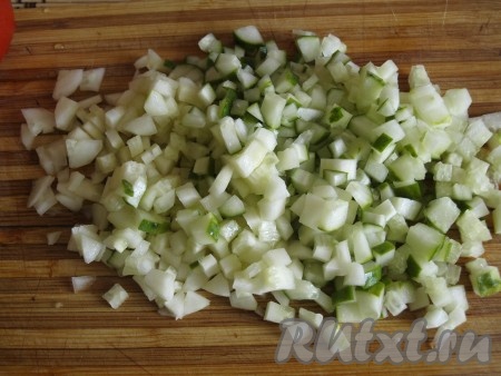 Кубиками нарезать огурцы.