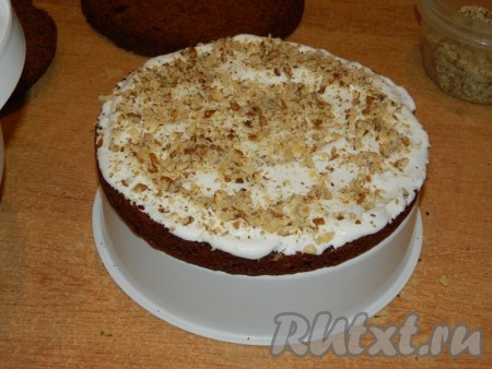 Смазать коржи кремом и посыпать орехами.