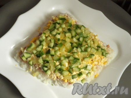 Свежий огурчик нарезать кубиками, выложить на яйца и смазать майонезом.