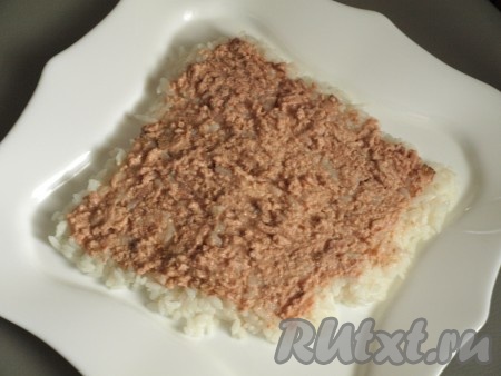 Тунца (без жидкости) размять вилкой и выложить поверх риса.