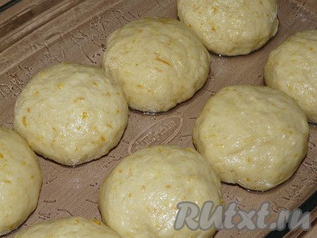 Форму для выпекания смазать растительным маслом. Готовое тесто хорошо обмять, разделить на 8-10 частей. Сформировать ровные шарики и выложить их в форму. Оставить творожные дрожжевые булочки для подъёма на 30-40 минут.
