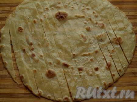 Блин (например, светлый) разрезаем не до конца на полоски шириной по 0,7 см.
