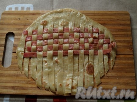 Свекольный блинчик разрезаем на полоски и начинаем плетение: через одну поднимаем белые полоски и выкладываем розовую полоску. Следующий ряд плетём в шахматном порядке. Так продолжаем плести ряд за рядом.
