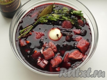 Заливаем говядину с овощами красным вином, добавляем букет гарни, подсолнечное масло и перемешиваем деревянной ложкой.
