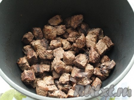 Разогреваем в чугунной кастрюле сливочное и подсолнечное масло, кладём говядину и обжариваем. Лишний жир сливаем в отдельную ёмкость (он нам ещё понадобится).
