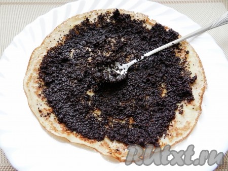 Маковую начинку намазать на блинчик и свернуть его рулетом.