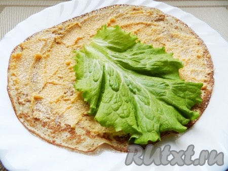 Выложить по 1-2 листика салата и свернуть блин рулетом.