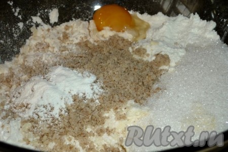 Добавляем желток, разрыхлитель, орехи и сахар.
