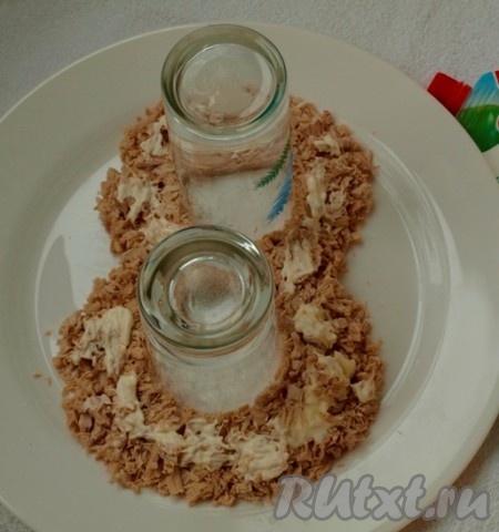 Нарезаем кубиками куриную грудку, чернослив и лук. Яйца разделяем на белки и желтки. Желтки натираем на мелкой тёрке, а белки оставляем для оформления. На плоскую тарелку ставим 2 стакана и выкладываем куриную грудку в виде цифры 8. Все слои смазываем майонезом.
