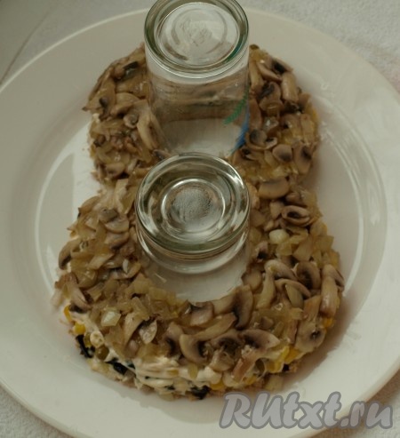 Нарезаем пластинками шампиньоны и обжариваем их на растительном масле вместе с оставшимся луком. Выкладываем сверху слоя горошка и кукурузы.
