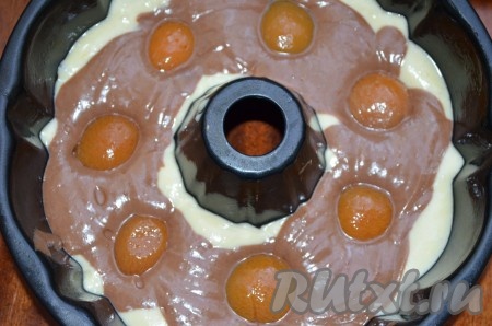 В оставшееся тесто добавить какао, перемешать. Выложить поверх светлого теста. Сверху утопить, но не до дна, половинки абрикосов, количество по вашему вкусу. Поставить в духовку, разогретую до температуры 180 градусов, примерно на 40 минут. Готовность проверять зубочисткой.
