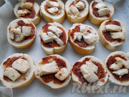 Каждый ломоть хлеба смазать томатным соусом и выложить обжаренные кусочки курицы (или кусочек варёной колбасы).