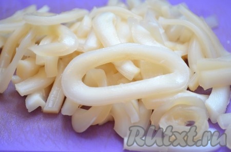 Для того чтобы сварить кальмара, его нужно опустить в кипящую воду и варить 2 минуты после закипания воды. Затем очистить от пленок и хорды. Отварного кальмара порезать кольцами или полукольцами.