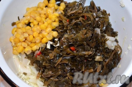 В миске смешать пекинскую, морскую капусты, кальмара, кукурузу, выдавить чеснок, посолить, поперчить, заправить салат маслом.
