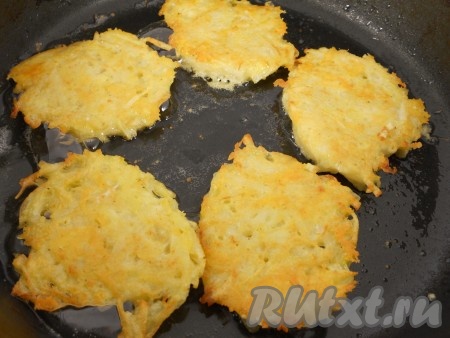 Влить растительное масло в сковороду, хорошо разогреть. Выкладывать на сковороду по 1-1,5 столовых ложки картофельно-сырного теста, формируя плоские драники. Жарить драники на среднем огне с двух сторон до красивой румяной корочки, затем перекладывать на тарелку.