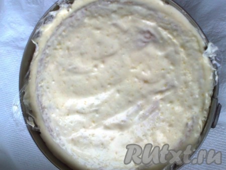 Выложите на второй корж остатки белкового крема. Крем должен лишь слегка прикрыть корж, выровняв его поверхность.