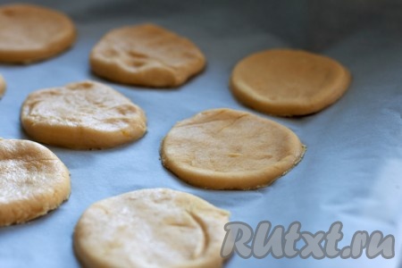 Раскатайте тесто в пласт толщиной 5 мм. Круглой или другой формочками (можно воспользоваться стаканом) вырежьте будущее печенье и выложите на противень.