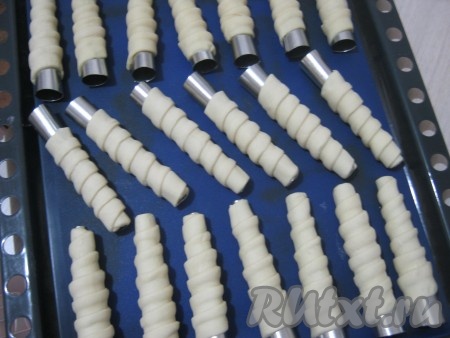 Подготовленные трубочки из слоеного теста складываем на лист, застеленный пергаментом, или силиконовым листом.
