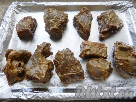 Разогреть духовку до 200 градусов. Свиные ребрышки разложить на противне, поставить в духовку и запекать в течение 45 минут. Через 25-30 минут от начала запекания перевернуть ребрышки другой стороной и запекать до готовности.