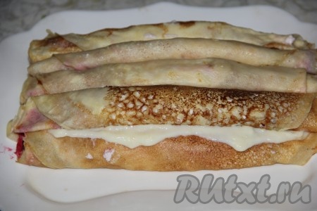 Для приготовления крема нужно молоко довести до кипения. В отдельной миске взбить яйца с сахаром и мукой. К яичной массе влить тонкой струйкой горячее молоко, взбить все венчиком и отправить на огонь. Варить при интенсивном помешивании до загустения. Готовый крем остудить и добавить в него творожный сыр.
Блины выложить пирамидкой, смазывая каждый слой блинного торта заварным кремом. Нижний (первый) ряд состоит из 5 блинов, второй - из 4, и так далее, уменьшая в каждом последующем ряду количество блинчиков на один.