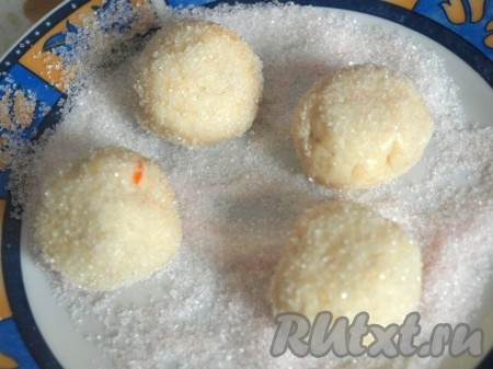 Смешать сахар и вторую пачку ванильного сахара. Скатать тесто в шарики размером с крупную сливу. Обвалять в сахарной смеси.
