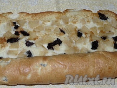 Достать противень из духовки. Испечённое тесто с фруктами перевернуть на тканевое полотенце, аккуратно убрать бумагу. В тёплом виде аккуратно завернуть бисквит с яблоками в рулет.