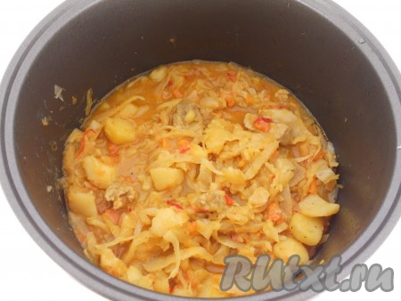 По истечении 45 минут в чашу мультиварки добавить томатную пасту, разведённую в небольшом количестве воды, и нашинкованную капусту. Закрыть мультиварку крышкой и готовить на режиме "Тушение" 25-30 минут. За 10 минут до окончания готовки добавить измельчённый чеснок и лавровые листья. После сигнала оставить блюдо под закрытой крышкой ещё на 15 минут.