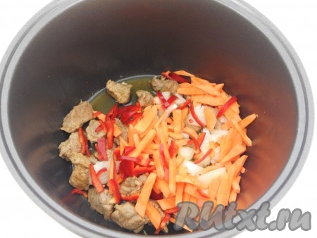 После того как свинина обжарится в течение 15 минут, выложить к ней лук, болгарский перец и морковку, продолжать готовить на том же режиме ещё 10 минут, не забывая периодически перемешивать.