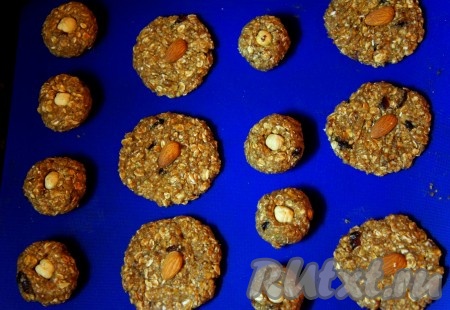 Духовку разогреть до 180 градусов. Противень застелить бумагой для выпечки или силиконовым ковриком. Влажными руками сформировать печенье (круглой, овальной и т.д. формы, как больше нравится). Каждое печенье украсить орешком.
