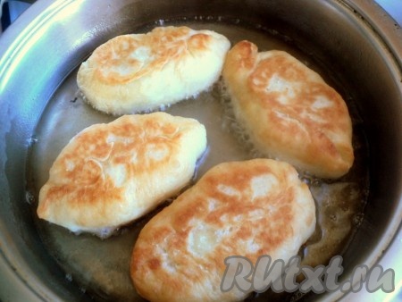 В глубокой сковороде разогреть достаточно большое количество растительного масла, выложить пирожки швом вниз. Масло должно доходить примерно до середины пирожков. Жарить пирожки на среднем огне с двух сторон до румяной корочки. Готовые пирожки с зелёным луком и яйцом выложить на бумажное полотенце, чтобы убрать лишнее масло.