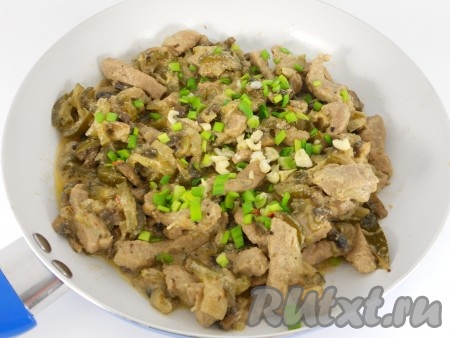 В конце тушения добавить в сковороду нарезанный чеснок и специи. По желанию, посыпать измельчённым зелёным луком. Перемешать и убрать с огня.