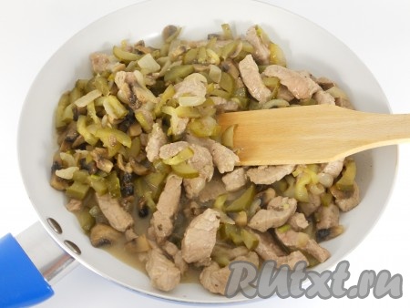 К луку с грибами добавить свинину с огурцами, перемешать и обжаривать всё вместе 10-15 минут на среднем огне, периодически перемешивая.