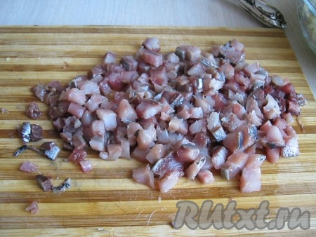 Сельдь очищаем от кожи и косточек. Полученное филе режем на мелкие кусочки.&nbsp;
