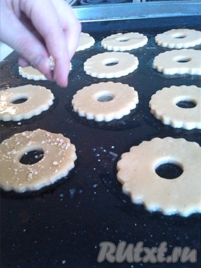 Посыпаем песочные кольца измельчёнными орехами и ставим выпекаться в разогретую до 200-220 градусов на 10-15 минут (до подрумянивания).