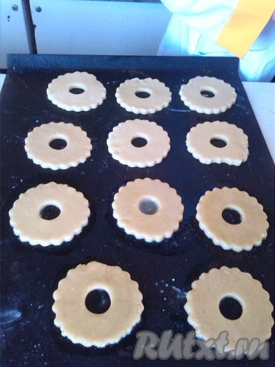 Выкладываем кольца на сухой противень (противень предварительно можно застелить пергаментом). Смазываем заготовки из песочного теста яйцом.