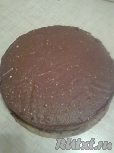 Накройте другим коржом. Верх и бока торта промажьте шоколадным кремом.
