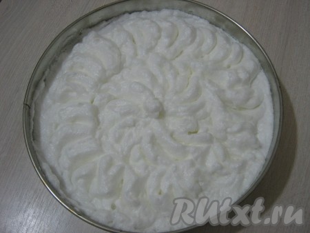 По истечении 30 минут достаём нашу форму и уменьшаем градусы в духовке до 160. Взбитые белки выкладываем в горячую форму поверх творожной начинки и равномерно распределяем. Затем с помощью ложки немного "взбудораживаем" белки, при запекании верх торта будет смотреться красивее. Опять ставим форму в духовку на 10 минут.