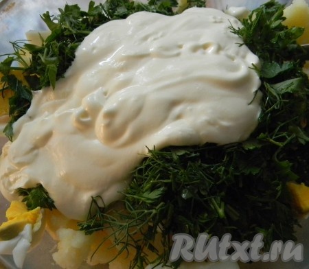 В картошку добавить яйца, измельченную зелень укропа и петрушки, заправить сметаной, поперчить, при необходимости посолить.
