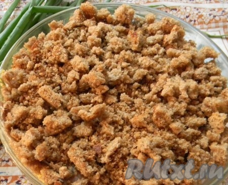 Перемешать, снизив таким образом температуру картошки. Выложить слой кильки и притрусить хлебной крошкой.
