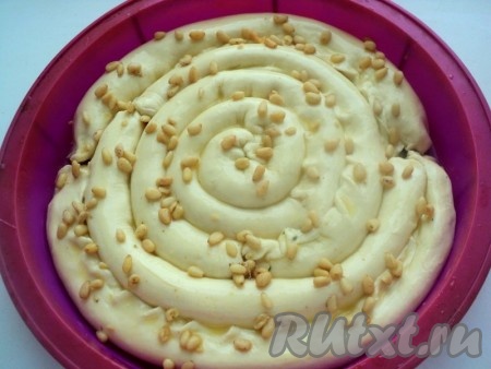 Форму для запекания смазать маслом. Полученные трубочки выложить в форму в виде улитки, начиная с середины. Пирог с щавелем смазать взбитым яйцом и, по желанию, посыпать кедровыми орешками или кунжутом. Выпекать в разогретой духовке при температуре 180 градусов 35 минут (до румяности).